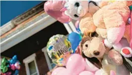  ?? KARL MERTON FERRON/BALTIMORE SUN ?? “You’ll Be Missed” reads a balloon along a fence beneath the charred rooftop of a home that caught fire Saturday, where three children died.