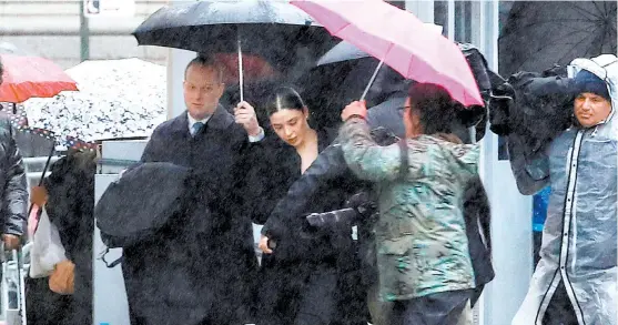  ?? MIKE SEGAR/REUTERS ?? La mujer del capo al salir de la Corte con personas que la protegen de la lluvia y la alejan de los periodista­s.