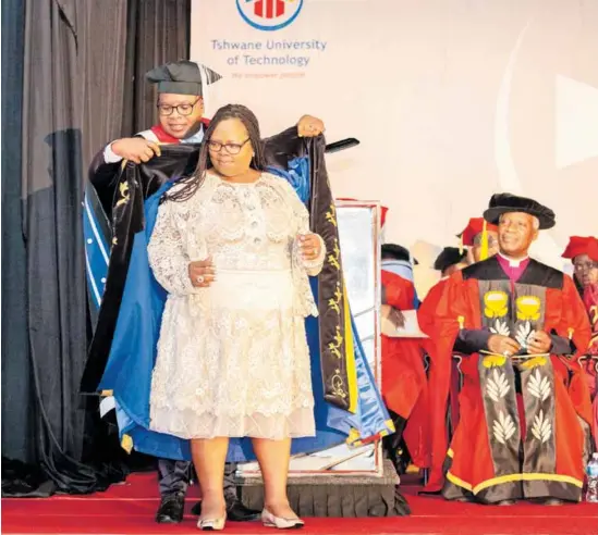  ?? ?? TUT Registrar Dr Michael Mushaathon­i robes the new TUT Chancellor Dr Gloria Serobe.