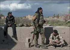  ?? Felipe Dana/Associated Press ?? U.S.-backed Syrian Democratic Forces fighters stand in an area recently taken by SDF as fighting against Islamic State militants continues Sunday in the village of Baghouz, Syria.