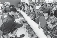  ?? PENG HUAN / FOR CHINA DAILY ?? Customers line up for a bowl of at the World Rice Noodles Expo in Nanning, Guangxi Zhuang autonomous region, in November.