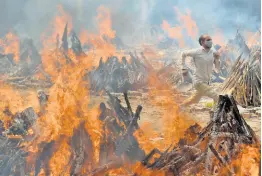  ?? AP ?? A man runs to escape heat emitting from the multiple funeral pyres of COVID-19 victims at a crematoriu­m in the outskirts of New Delhi, India. India’s excess deaths during the pandemic could be a staggering 10 times the official COVID-19 toll, likely making it modern India’s worst human tragedy, according to the most comprehens­ive research yet on the ravages of the virus in the south Asian country.