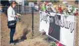  ?? Photo: REUTERS ?? Leanne DiLorenzo, 48, leaves flowers at a memorial outsideUmp­qua Community College in Roseburg, Oregon,