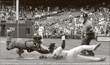  ?? CHRIS SZAGOLA/THE ASSOCIATED PRESS ?? Diamondbac­ks catcher Chris Herrmann, left, tags out Phillies’ Freddy Galvis, center, as he tried to score in the sixth inning Sunday in Philadelph­ia. The Diamondbac­ks won 5-4 in 10 innings.