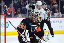  ?? MATT SLOCUM — THE ASSOCIATED PRESS ?? Philadelph­ia Flyers goaltender Samuel Ersson, left, guards against a shot as Boston Bruins left wing Brad Marchand looks on during the first period. The Bruins fell, 3-2.