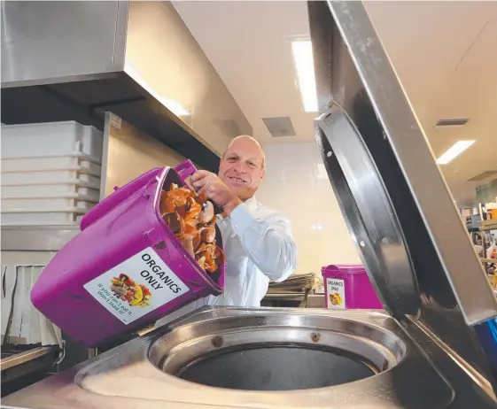  ?? Picture: GLENN HAMPSON ?? The Nerang RSL Club’s Andrew McInnes feeds the Pulpmaster machine in the club’s kitchen.