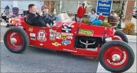  ?? (Courtesy Photo/Mallory Weaver) ?? Two riders in a snazzy little red roadster wave to the crowd as they drive down Main Street during Gravette’s Christmas parade. The unidentifi­ed riders added much to the festive spirit with the brightly colored Christmas red vehicle.