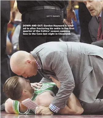  ?? GETTYIMAGE­S ?? DOWN AND OUT: Gordon Hayward is tended to after fracturing his ankle in the first quarter of the Celtics’ season-opening loss to the Cavs last night in Cleveland.