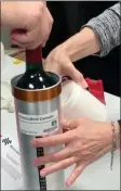  ?? The Associated Press ?? Researcher­s prepare bottles of French red wine to be flown to the Internatio­nal Space Station.