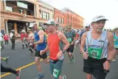  ??  ?? Arizona Republic reporter Bob Young (in orange) and Craig Davidson (No. 28) start the run.