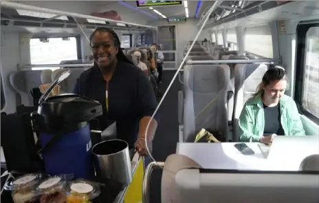  ?? Marta Lavandier/Associated Press ?? Brightline employee sells drinks and snacks on board a train Sept. 8 in Fort Lauderdale, Fla.