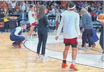  ?? ASSOCIATED PRESS ?? An official measures the 3-point line as NC State players warm up before an NCAA Tournament Elite Eight game against Texas on Sunday in Portland, Ore. The 3-point line at the Moda Center had a discrepanc­y in distance at each end of the court that went unnoticed through four games.