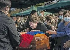  ?? A WOMAN Marcus Yam Los Angeles Times ?? grieves at the funerals of Kristapor Artin and Suren Vanyan, volunteer f ighters for Armenia in the war with Azerbaijan over Nagorno- Karabakh.