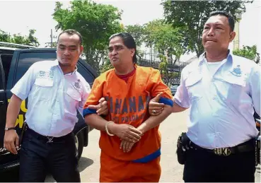  ?? — AFP ?? Facing trial: Pribadi being taken to police headquarte­rs in Surabaya after he was arrested for allegedly ordering the murder of two of his followers who had attempted to unmask him as a fraud.