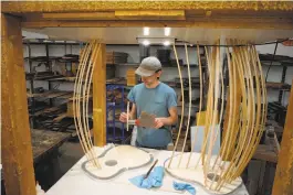  ?? Andy Murdock / Special to The Chronicle ?? Above center: Building instrument­s at Taylor Guitars. Above: Santa Cruz Guitar Co. builder Forrest McCoy uses a traditiona­l wooden dowel system to hold down bracing elements as they’re glued to a guitar soundboard.