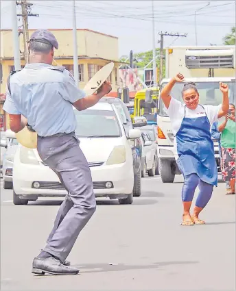  ?? Picture: FIJI POLICE FORCE ?? Traffic has to hold up as a woman dances with a policeman during the Fiji Police Force’s new year’s celebratio­n in Nabua early this year.