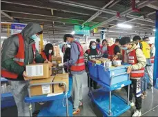  ?? WANG JING / CHINA DAILY ?? Workers sort parcels at a logistics center in Tongzhou district in Beijing on Wednesday.