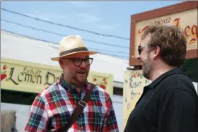  ?? LISA MITCHELL - MEDIANEWS GROUP ?? Douglas Madenford, a native of Centerport, Berks County, who is the main protagonis­t in the German film “Hiwee wie Driwwe – The Roots of PA Dutch,” talks with German film maker Benjamin Wagener during the 2019 Kutztown Folk Festival.