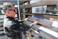  ?? ALEX HORVATH / THE CALIFORNIA­N ?? Kevin Russell, owner of American Fabricatio­n, shows an example of what the names will look like on a memorial wall his company has built for those who died of COVID-19. Russell is seeking the names of those who died to go on the wall.