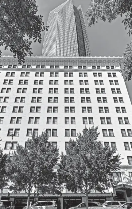  ?? CHRIS LANDSBERGE­R/THE OKLAHOMAN ?? The Devon Energy Center tower looms over the adjacent Colcord Hotel. Devon sold the hotel to local investors Mark Beffort and Andy Burnett on April 30.