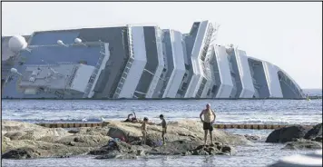  ?? AP ?? The Costa Concordia lies on its side near Italy’s Giglio Island. The ship, which was carrying 4,200 passengers, hit a reef on Jan. 13, 2012, when it was steered too close to the island.