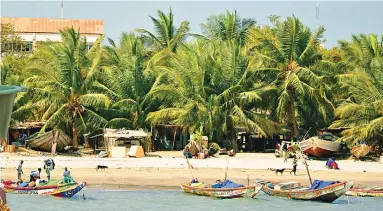  ?? ?? Carnival of colour: Fishing boats by a beach in The Gambia. Inset left, a fruit-seller