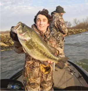  ?? DALE BOWMAN/FOR THE SUN-TIMES ?? Chaser Ellison of Morris shows off the best largemouth bass of the day Sunday on opening day at Braidwood Lake.