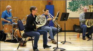  ?? NEWS-SENTINEL PHOTOS BY WES BOWERS ?? Above: The Stockton Symphony's brass quintet and drums performed swing and jazz music at the Lodi Boy and Girls Club Friday as part of its new "The Magic of Music" program. Brian Kendrick (drums), Ruth Brittin (French horn) and Samuel Wamhoff (trombone). Below: Wamhoff pulls his instrument apart to show youngsters how the instrument makes its sounds.