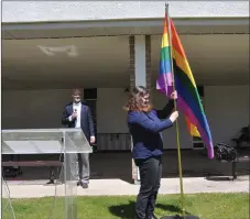  ?? Photos by Matthew Liebenberg/Prairie Post ?? SCCHS student and QSA member Kylie Dyke places the Pride flag on a stand at the start of the ceremony, June 3.