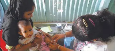  ?? Agence France-presse ?? ±
A health worker administer­s a vaccine to a child at a temporary vaccinatio­n camp following a measles outbreak in Mumbai on Wednesday.