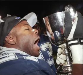  ?? (AP/Tom Hanson/The Canadian Press) ?? Mike Pringle of the Baltimore Stallions gives the Grey Cup a kiss after the Stallions won the 1995 Grey Cup. The Stallions were the only United States-based team to win the Canadian Football League title.