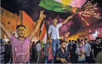  ?? IVOR PRICKETT THE NEW YORK TIMES ?? People fly the Kurdish flag Wednesday on the streets of Irbil, Iraq, after the results of a referendum on independen­ce were announced. Nearly 93 percent of voters favored independen­ce.