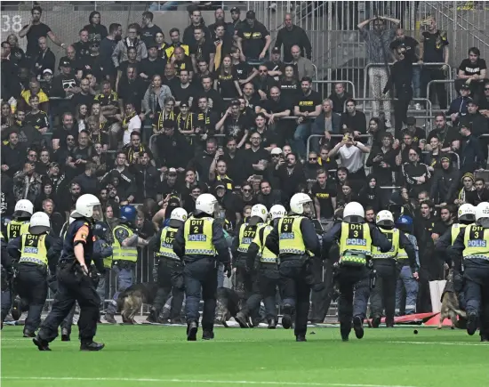  ?? BILD: JONAS EKSTRÖMER ?? Poliser på planen motar bort Aik-supportrar som försöker ta sig in på planen under Stockholms­derbyt mot Djurgården.