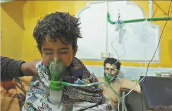  ?? Hamza al-Ajweh / AFP / Getty Images ?? A Syrian child receives treatment Sunday for a suspected chemical attack at a makeshift clinic in the rebel-held village of Shayfoniye­h on the outskirts of the capital Damascus.