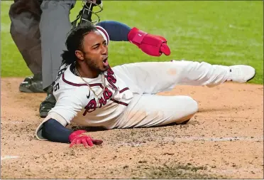  ?? TONY GUTIERREZ/AP PHOTO ?? Atlanta’s Ozzie Albies scores on a double by Dansby Swanson during the sixth inning of Thursday’s night’s National League Championsh­ip Series game against the Los Angeles Dodgers in Arlington, Texas. The Braves beat the Dodgers 10-2 to take a 3-1 series lead. Game 5 ended too late for this edition. Visit theday.com for complete recap.