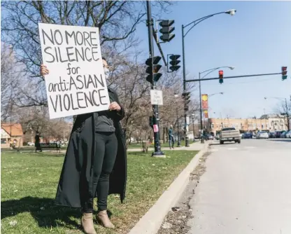  ?? MENGSHIN LIN/SUN-TIMES ?? Tina Nguyen, 28, of Logan Square, holds a sign to send a message on March 20.