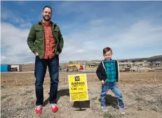  ?? AP Photo/David Zalubowski ?? ■ Chad Zolman, left, joins his 5-year-old son, Quinten, in standing at the site of their yet-to-be-constructe­d new home April 7 in Castle Rock, Colo. A tight housing market, further complicate­d by climbing interest rates and rising prices, has forced...