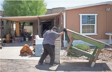  ?? PHOTOS BY MARK HENLE/THE REPUBLIC ?? Juan Martinez gets ready to move from the Tempe Mobile Home Park in mid-July. Martinez has lived there for eight years and is having his trailer moved to a Phoenix park. That isn’t an option for some residents.