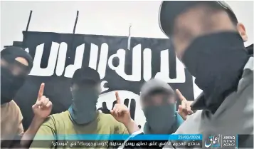  ?? ?? Standing in front of an Islamic State sign, the men each hold up one finger in a gesture that is now synonymous with the group