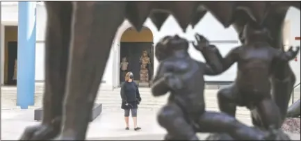  ?? (AP/Gregorio Borgia) ?? A visitor is framed by the large-scale bronze statue of the Capitoline Wolf, a she-wolf milking the twin-founders of Rome, at the Rome’s Capitoline Museum.
