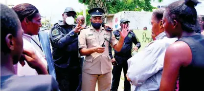  ??  ?? Acting Assistant Commission­er of Police Steve McGregor (left) and Superinten­dent Leighton Gray address the angry crowd.