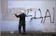  ?? ASSOCIATED PRESS ?? A worker paints over a writing reading ‘Yes to Peace!’ on a wall of an apartment building in St. Petersburg, Russia, Friday, March 18, 2022.