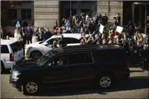  ?? ASTRID RIECKEN / GETTY IMAGES ?? Members of the media and demonstrat­ors gather around the car carrying Michael Flynn as he leaves after his plea hearing Friday in Washington, D.C.