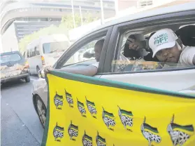  ?? Picture: Alaister Russell ?? CHEERLEADE­RS. ANC supporters wave flags outside the parliament­ary precinct in Cape Town yesterday.