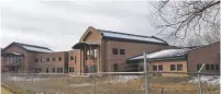  ?? COURTESY NEW MEXICO IN DEPTH ?? Mora County’s new two-story courthouse sits unfinished behind a chain-link fence in 2015.