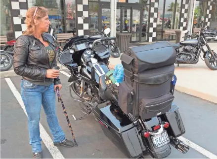  ?? MARK HOFFMAN/MILWAUKEE JOURNAL SENTINEL ?? Despite breaking her pelvis 10 weeks ago and still needing a cane to walk, Teresa Ballou of Port Angeles, Wash., waits for the start of her ride to Milwaukee on Tuesday at Destinatio­n Harley-Davidson in Tacoma, Wash. Tuesday was the first day of a nine-day Ride Home to Milwaukee for the company’s 115th anniversar­y observance, which runs through Labor Day weekend. The motorcycle maker is sponsoring four “rides home” from different corners of the country. Other starting points are San Diego; Portland, Maine; and Fort Lauderdale, Fla.