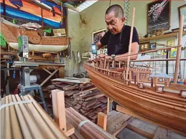  ?? BERNAMA PIX ?? Azhar Kamaruddin working on a Admiral Cheng Ho ship model, which is a popular choice among customers, at his workshop in Batu Gajah, Perak.