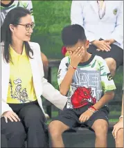  ??  ?? Rescued soccer player Chanin Vibulrungr­uang reacts after paying respect to a portrait of Saman Gunan, the Thai navy SEAL diver who died in the rescue attempt.