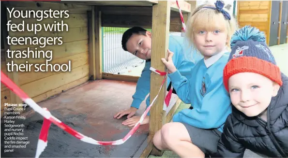  ??  ?? Please stop Pupil Council members Karson Finlay, Harley Sedgeworth and nursery pupil Rocko Caddis inspect the fire damage and smashed panel