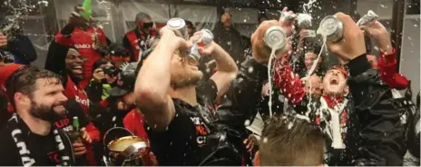  ?? STEVE RUSSELL/TORONTO STAR ?? Toronto FC players celebrate with some refreshmen­ts in their locker room after winning the MLS Cup on Saturday.